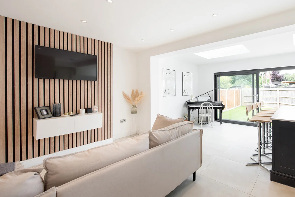 Kitchen painted white, with a TV media wall, with wood paneling