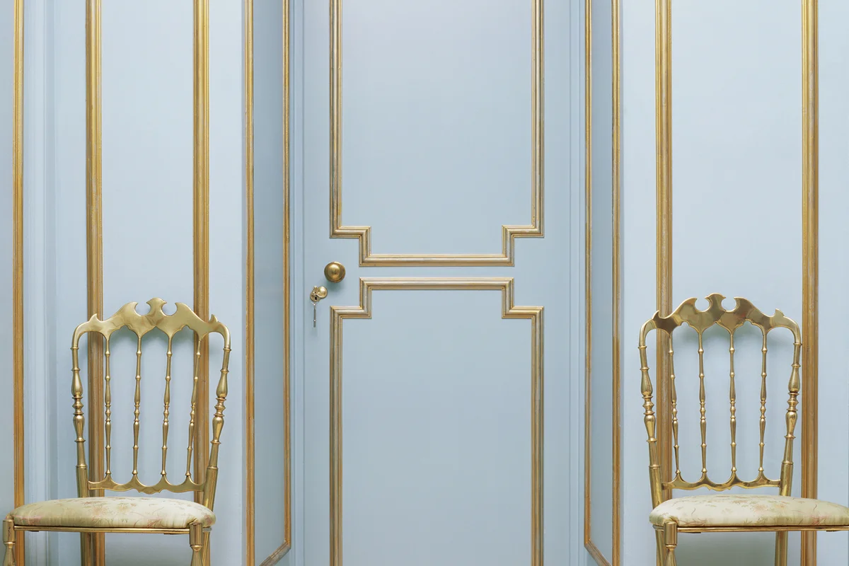Two gold chairs in an empty room
