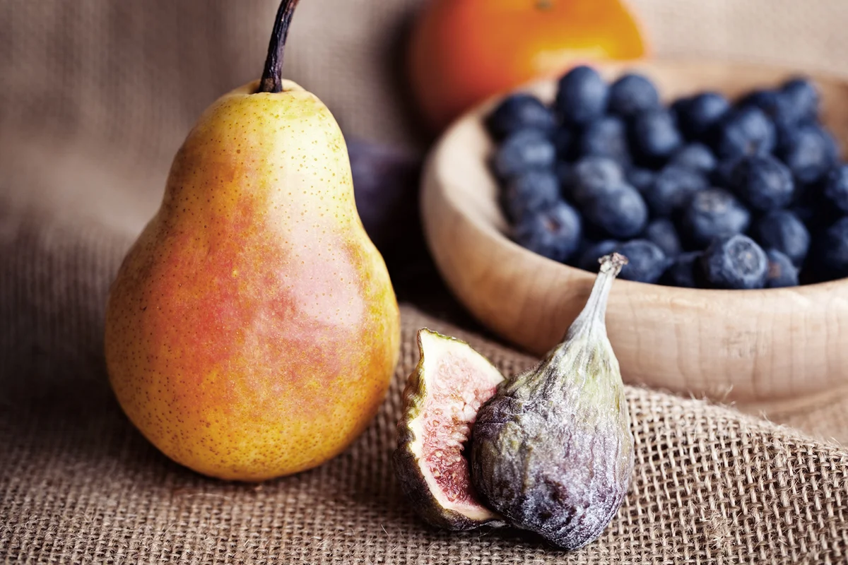 Pear, fig and a bowl with blue berries -