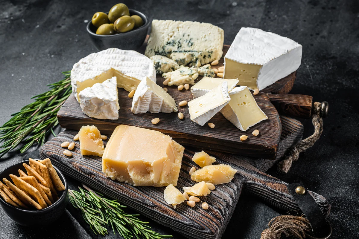 Assortment of cheese, camembert, brie, Gorgonzola, parmesan, olives, nuts and herbs