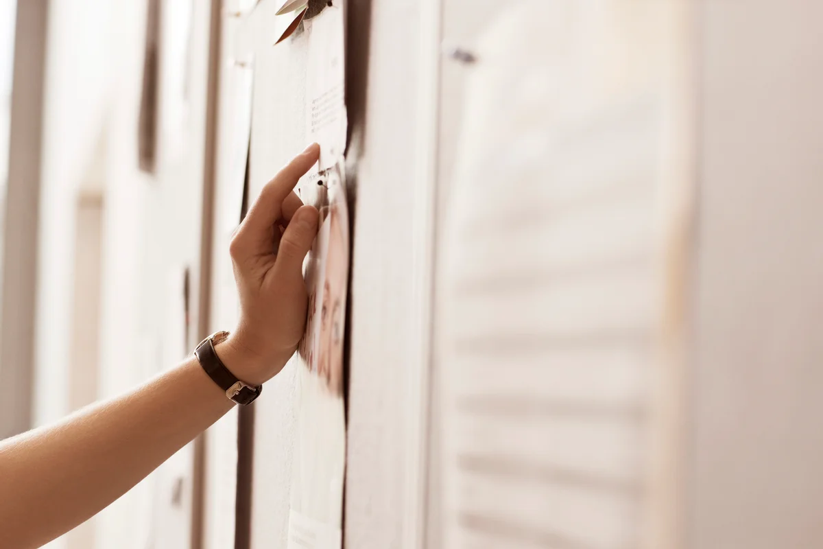 Woman's hand on noticeboard