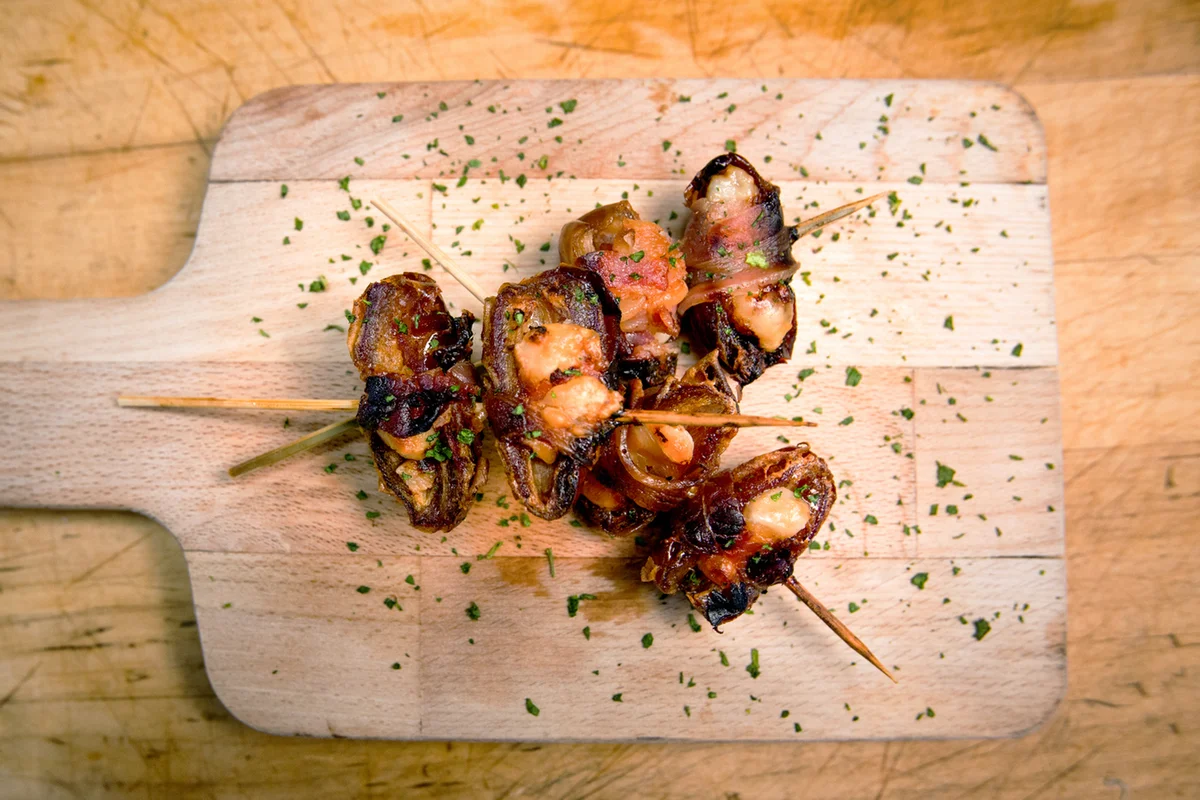 Italian Bacon Wrapped Dates Appetizer on a Rustic Cutting Board
