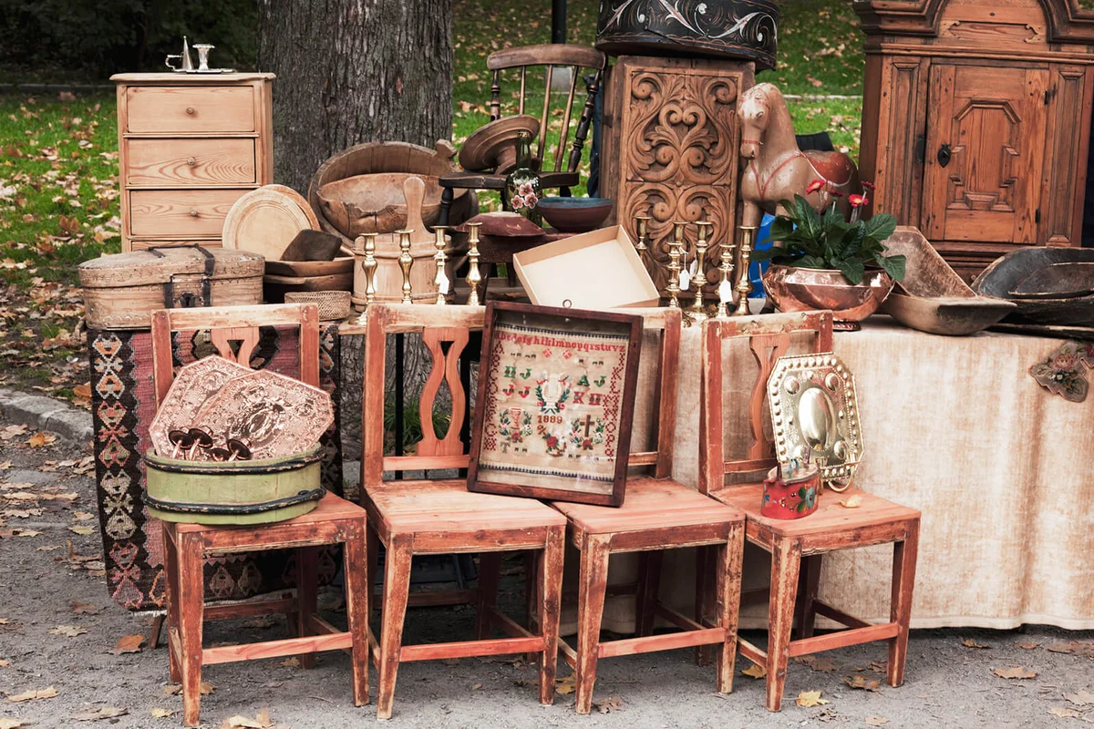 Stand at an outdoor market with antique wooden furniture