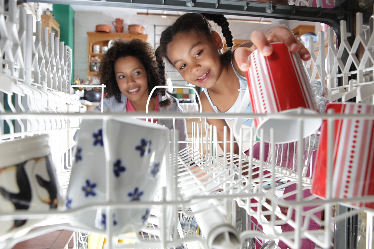 mother and daughter loading dishwasher