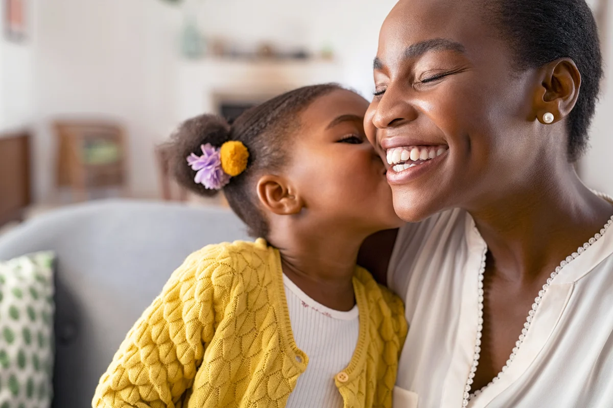Cute little girl kissing aunt on the cheek