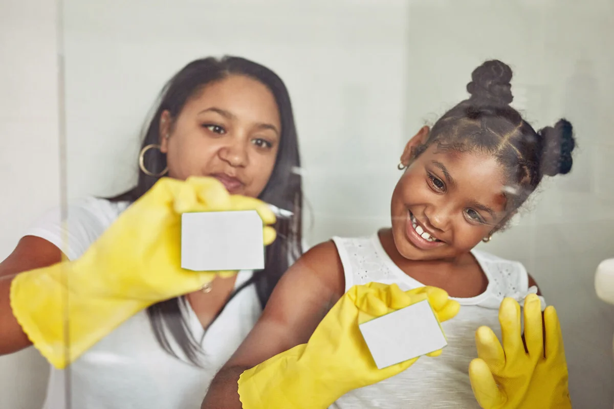 mother and her little daughter cleaning the bathroom together