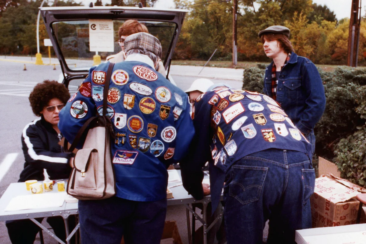 Two competitors wearing patch covered jackets, from the back