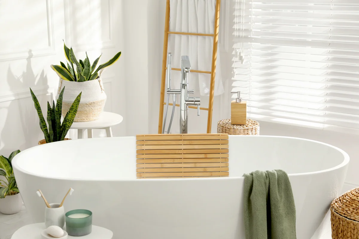 Stylish bathroom interior with green plants and ladder