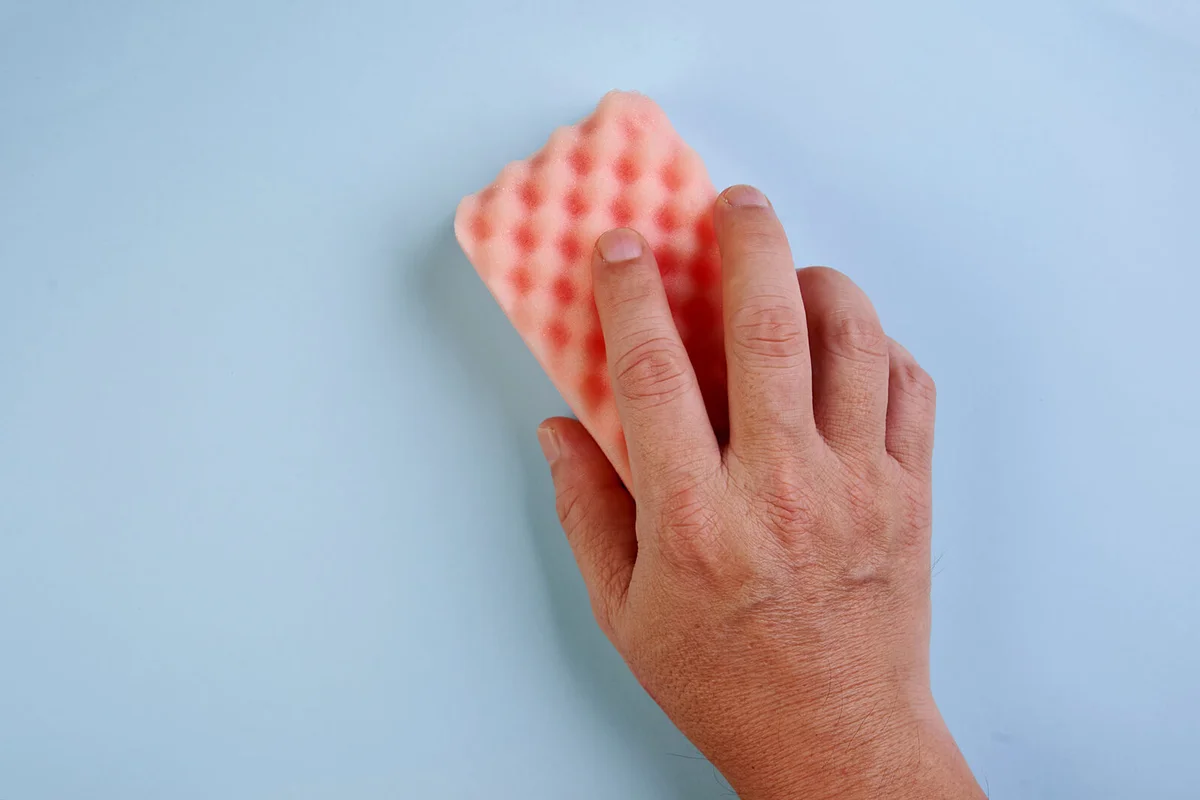 Male hand holding cleaning sponge