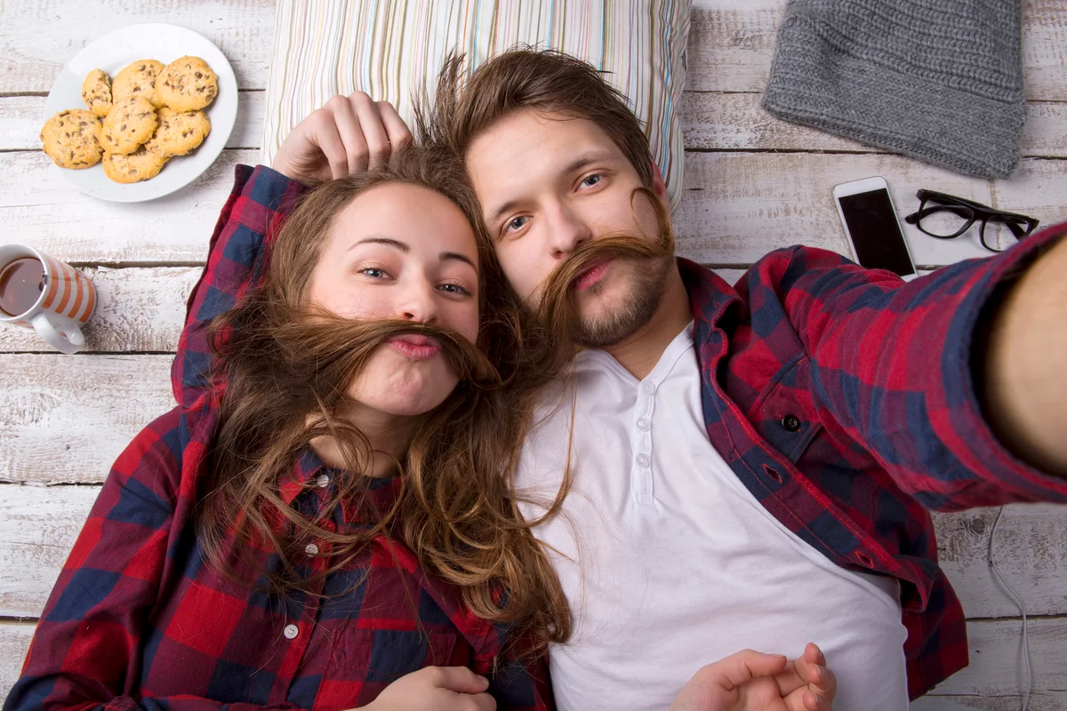 Young couple lying on the floor taking a selfie