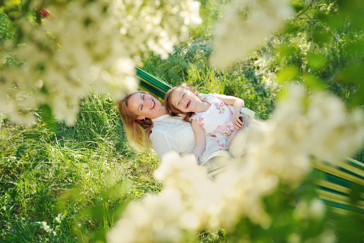 Mother and daughter laying in a hammock at spring time