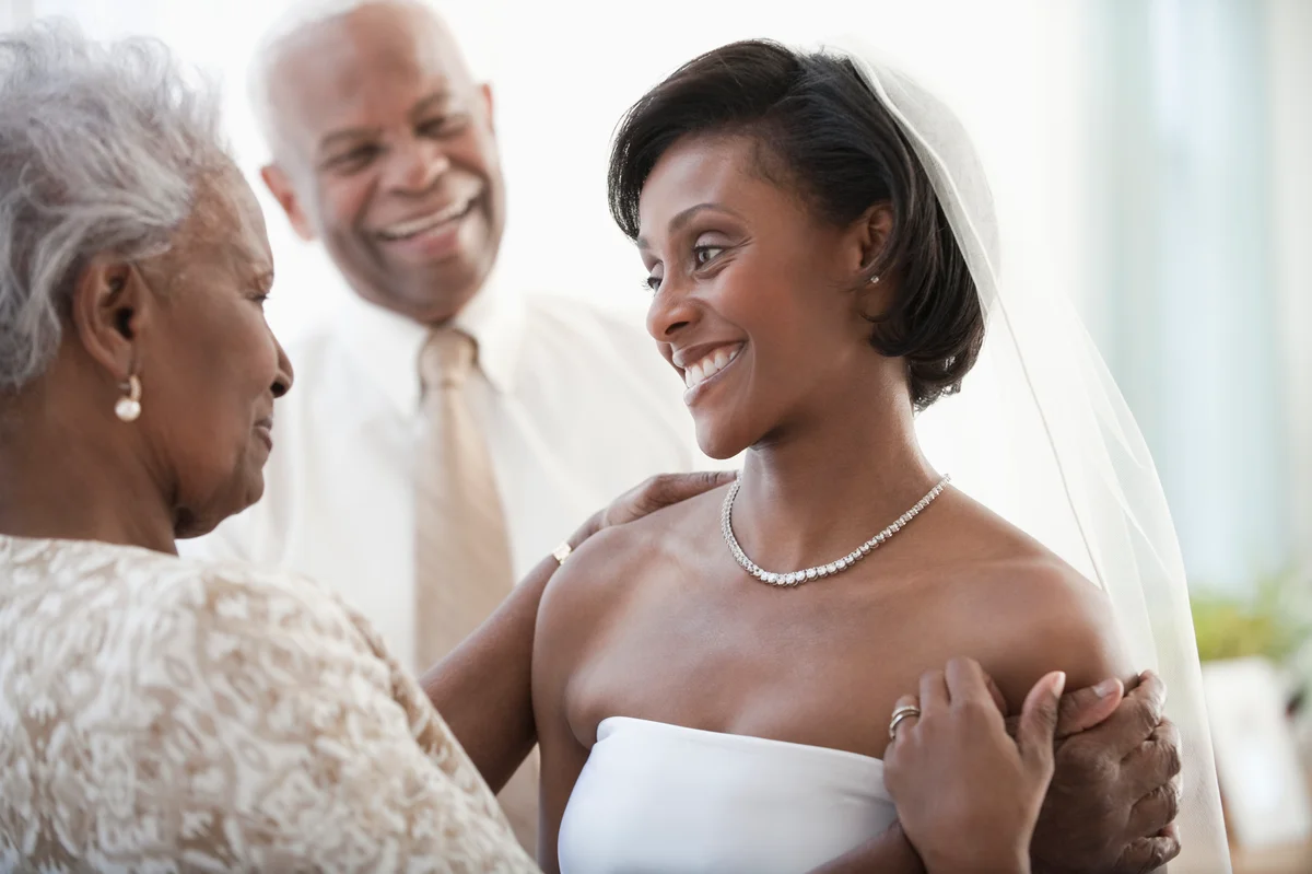 Grandparents helping granddaughter get ready on wedding day