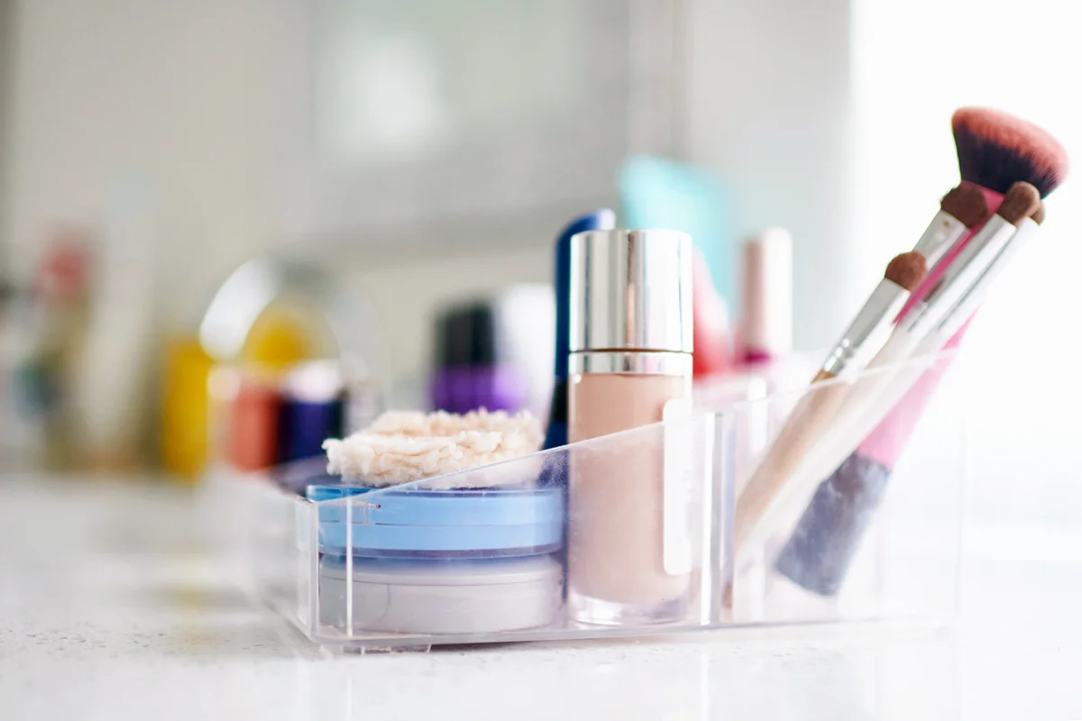 Make-up products and brushes in plastic container