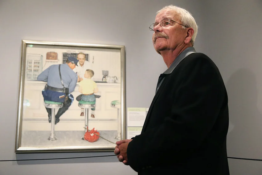 Ed Locke stands next to the 1958 Norman Rockwell painting