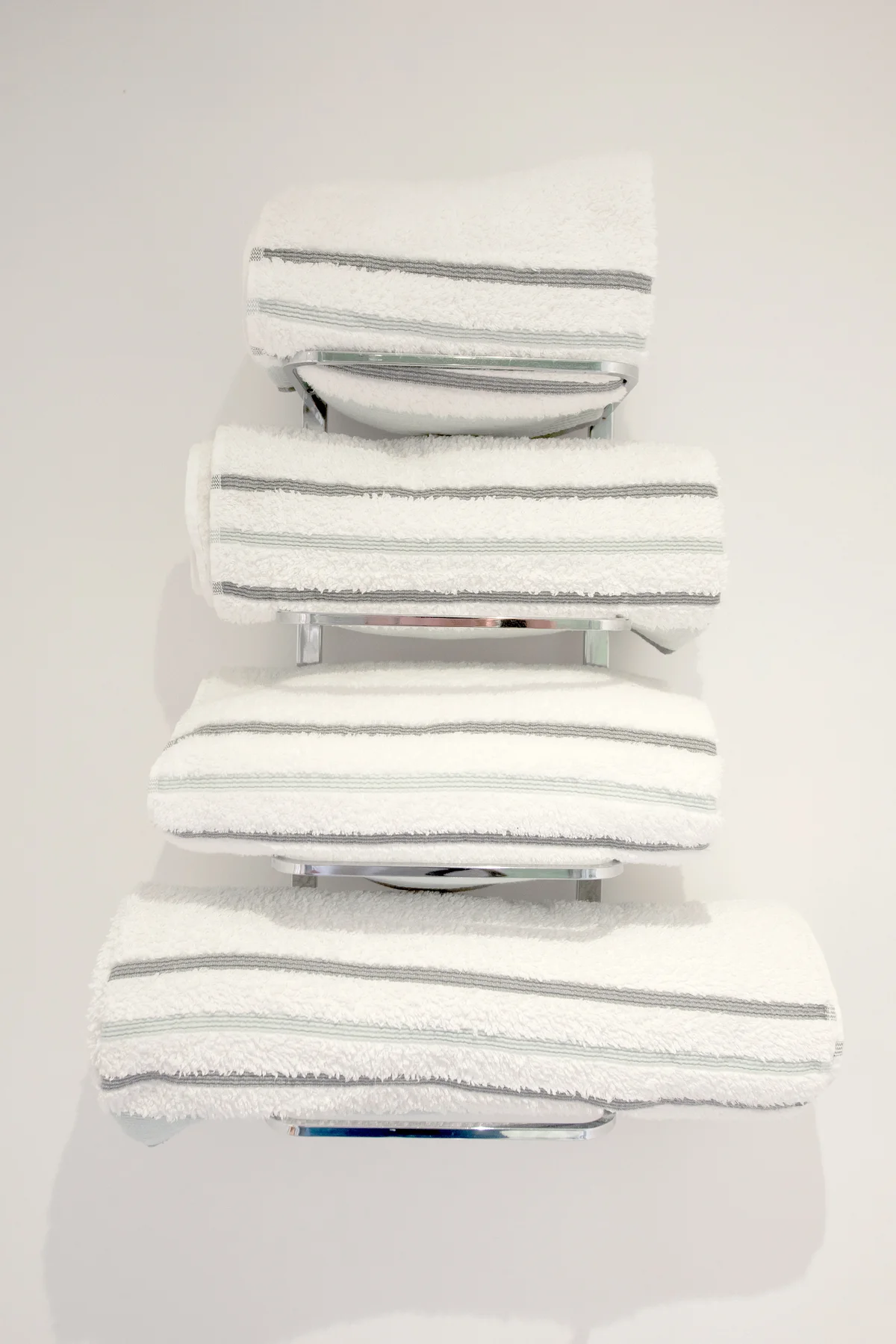 Chrome towel wall rack rail holding towels in a bathroom