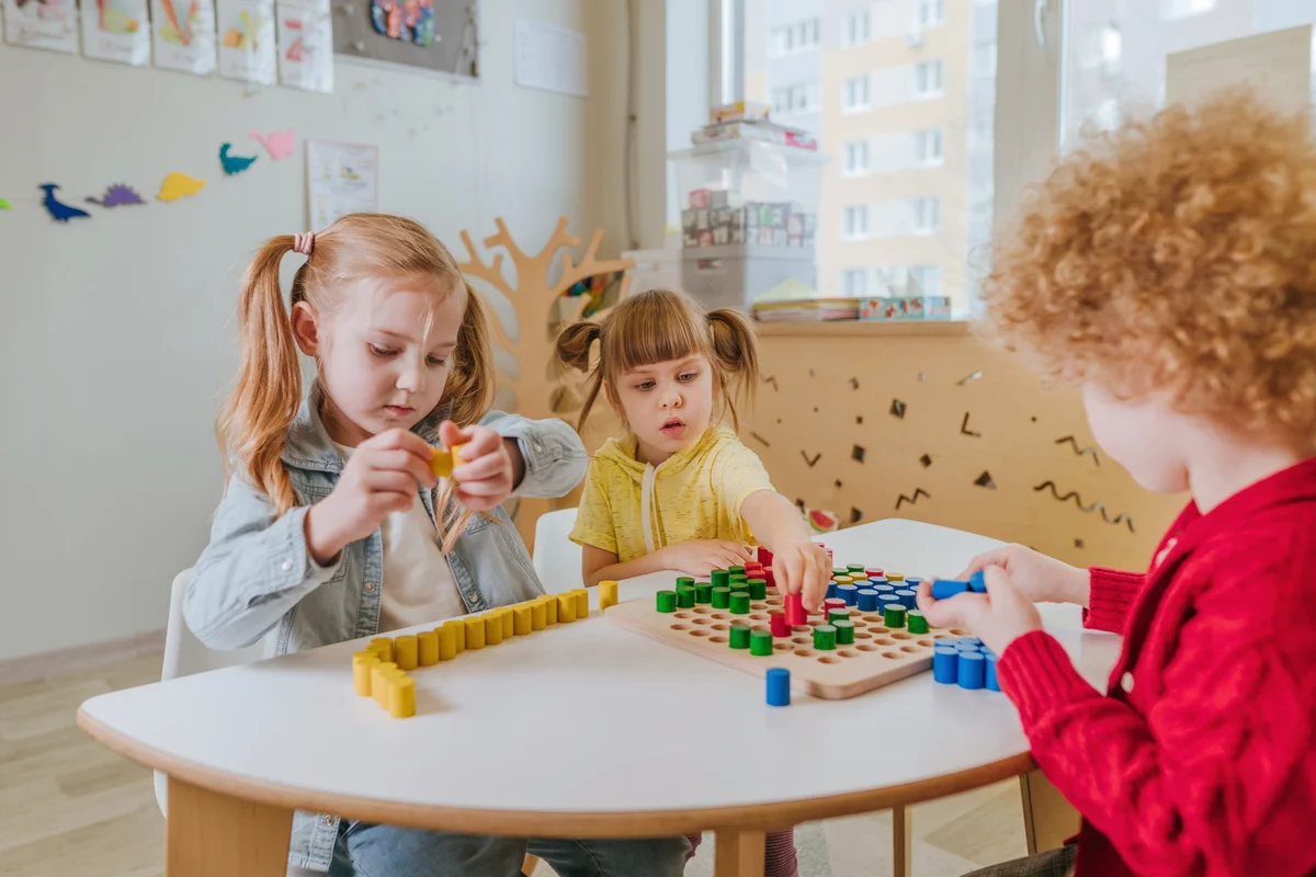 Preschool students playing with wooden mosaic