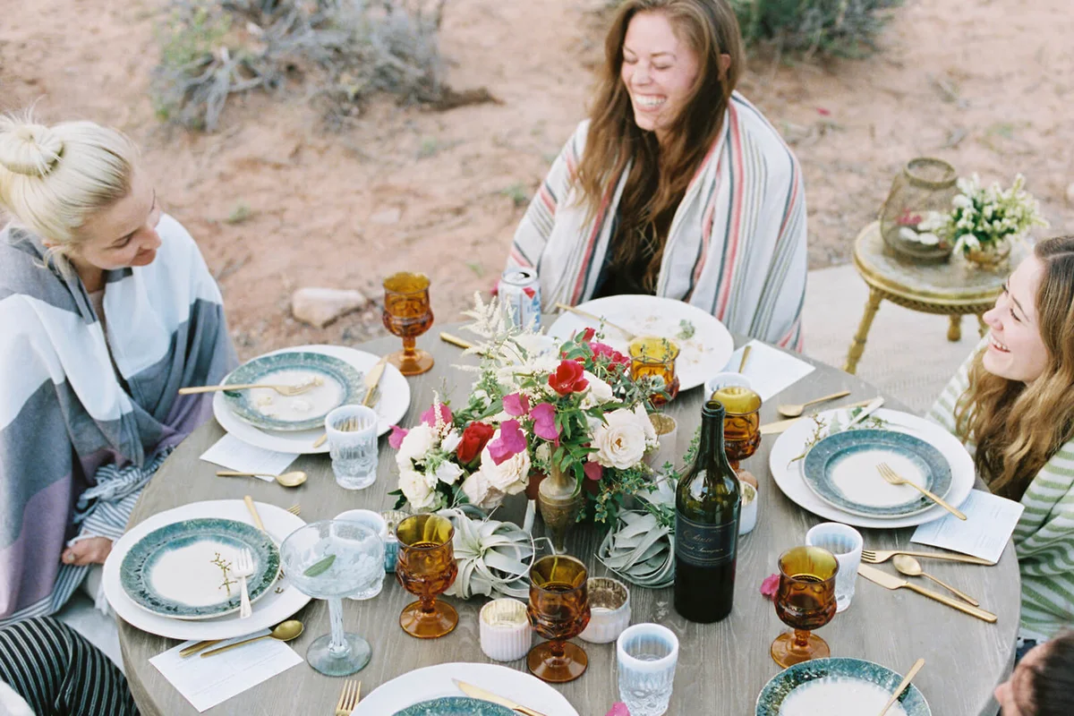 A small group of women enjoying an outdoor meal in a desert