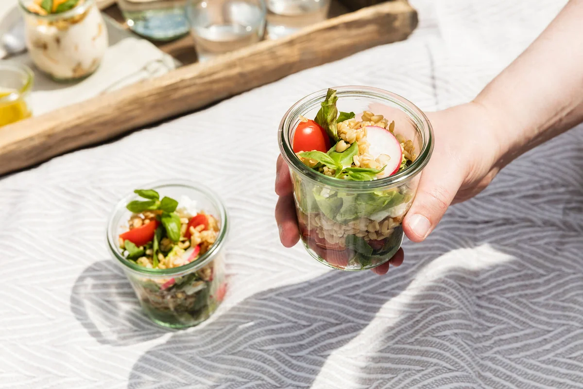 Person holding jar with vegetarian oat salad