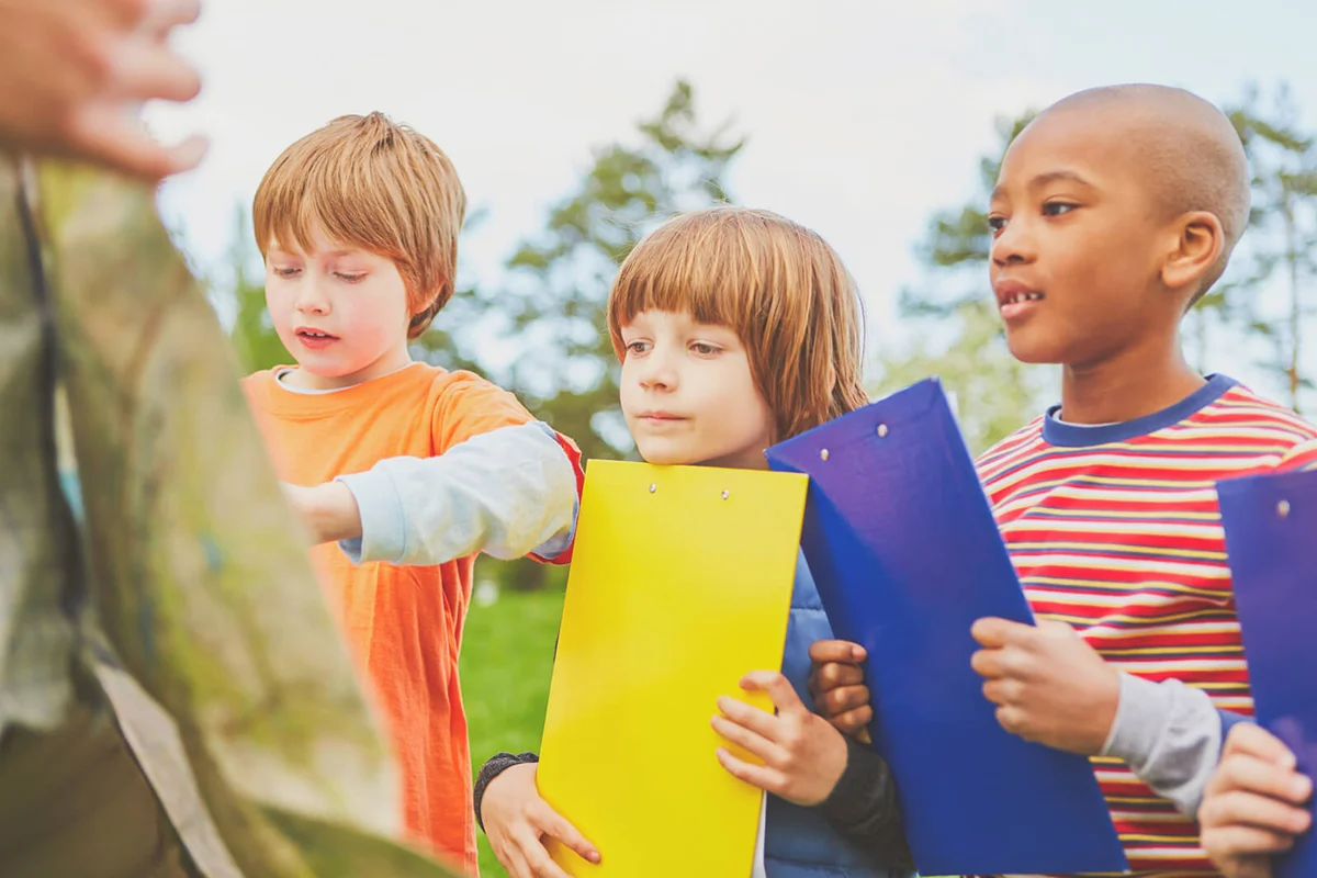 Friends Holding Clipboard In Park