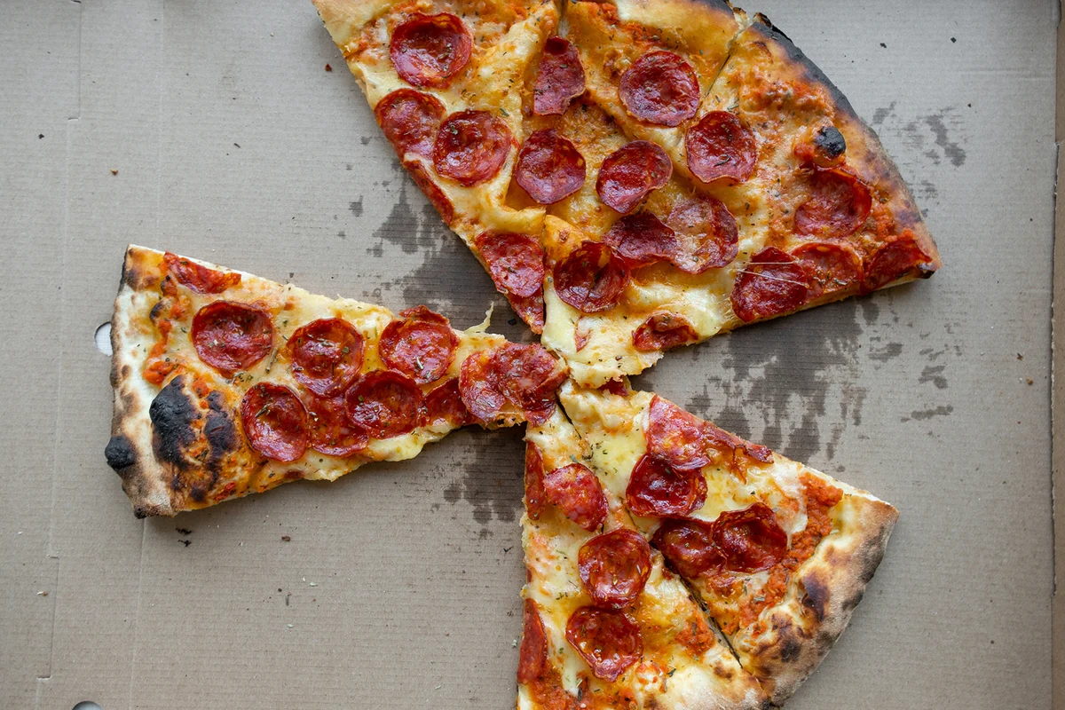Delicious Italian pizza in a pizza box and a delivery box, on the table in a pizzeria