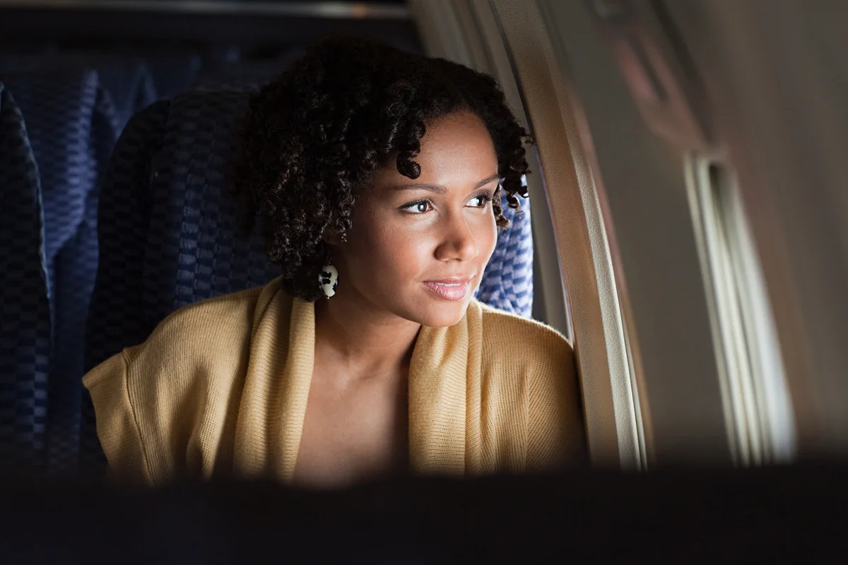 Female airplane passenger looking out of window