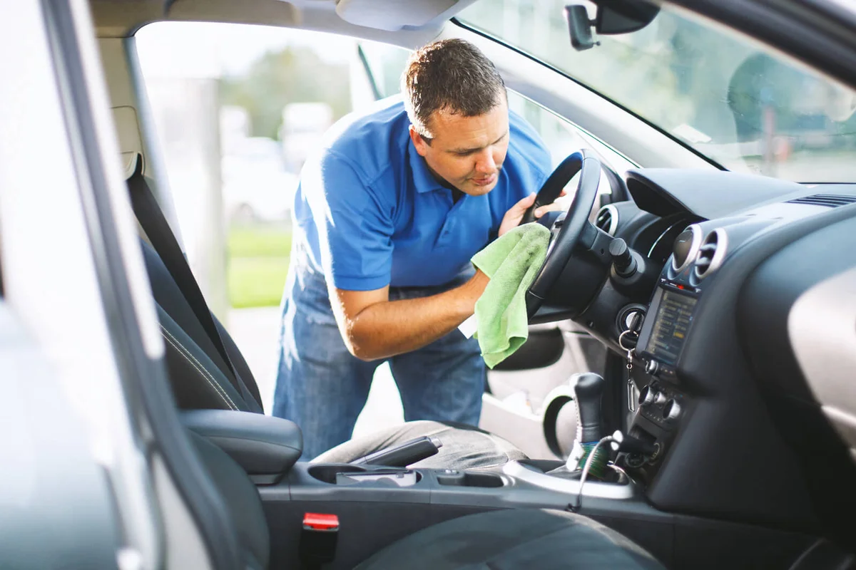 man cleaning upholstery of his car