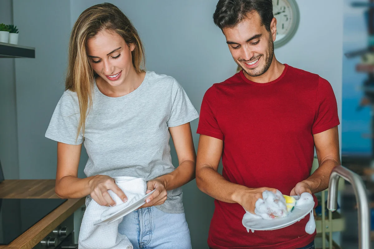 Couple indoors washing dishes