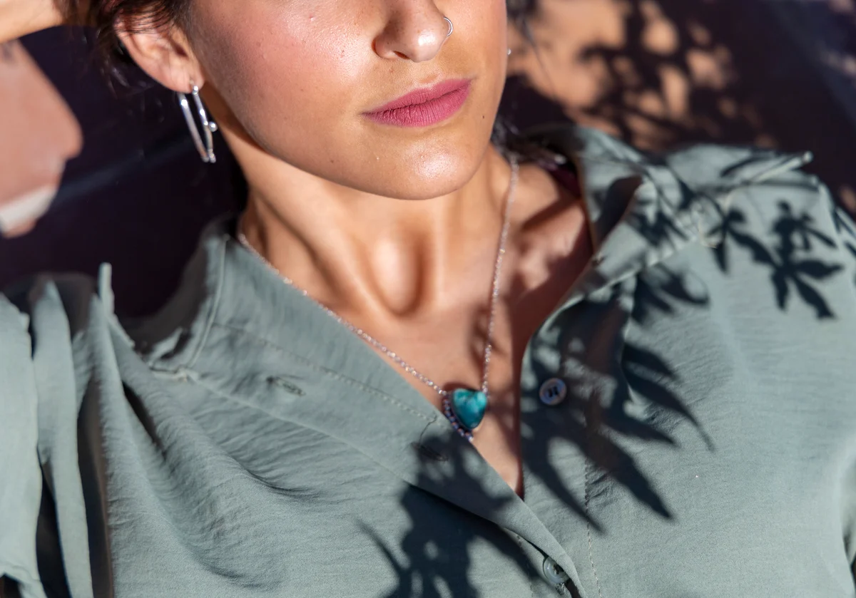 woman wearing turquoise heart-shaped pendant necklace
