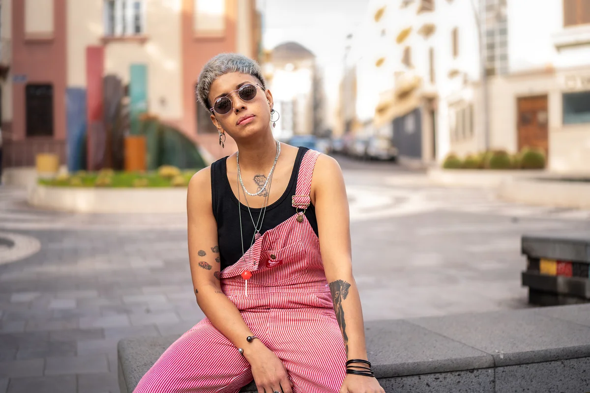 young woman with gender neutral style wearing long chains of neckaces