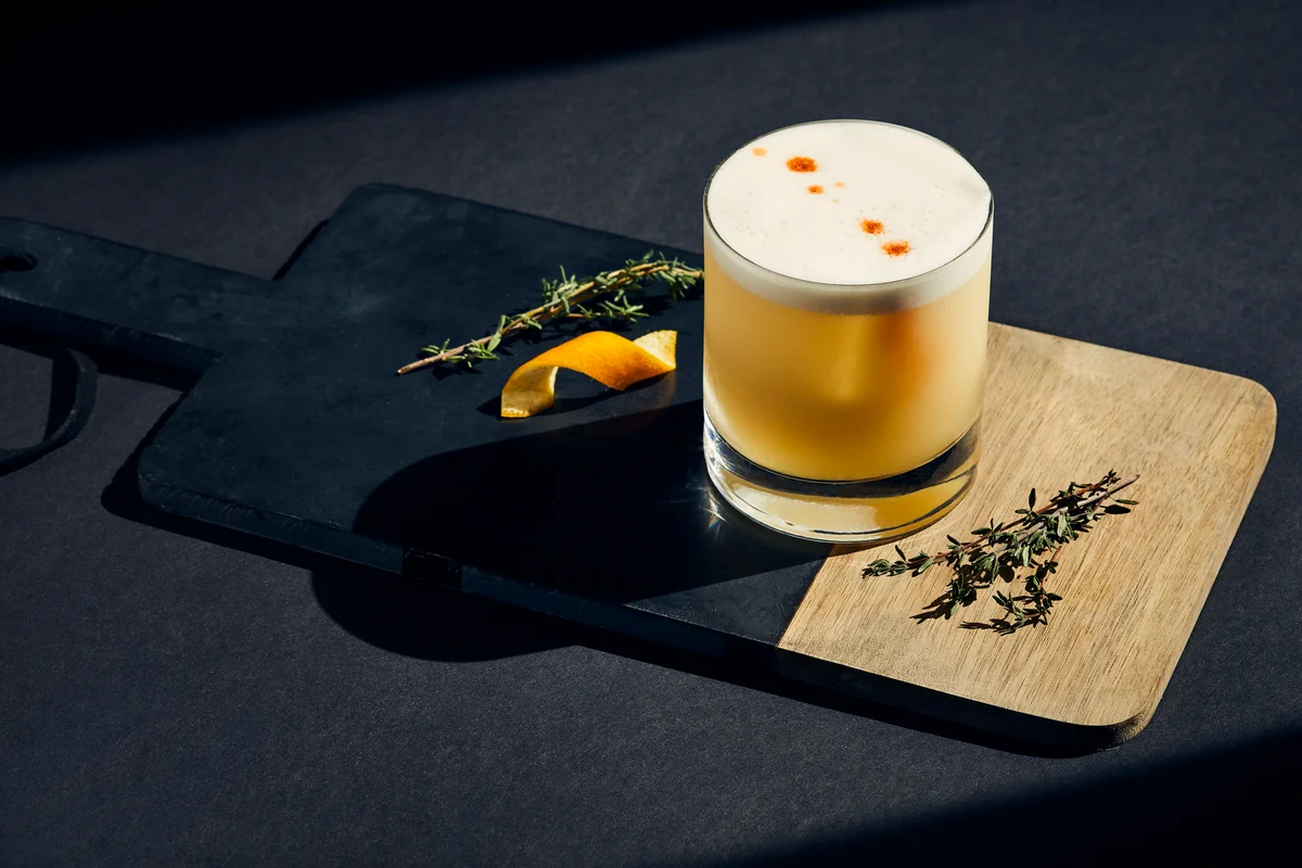 whiskey sour cocktail on a cutting board