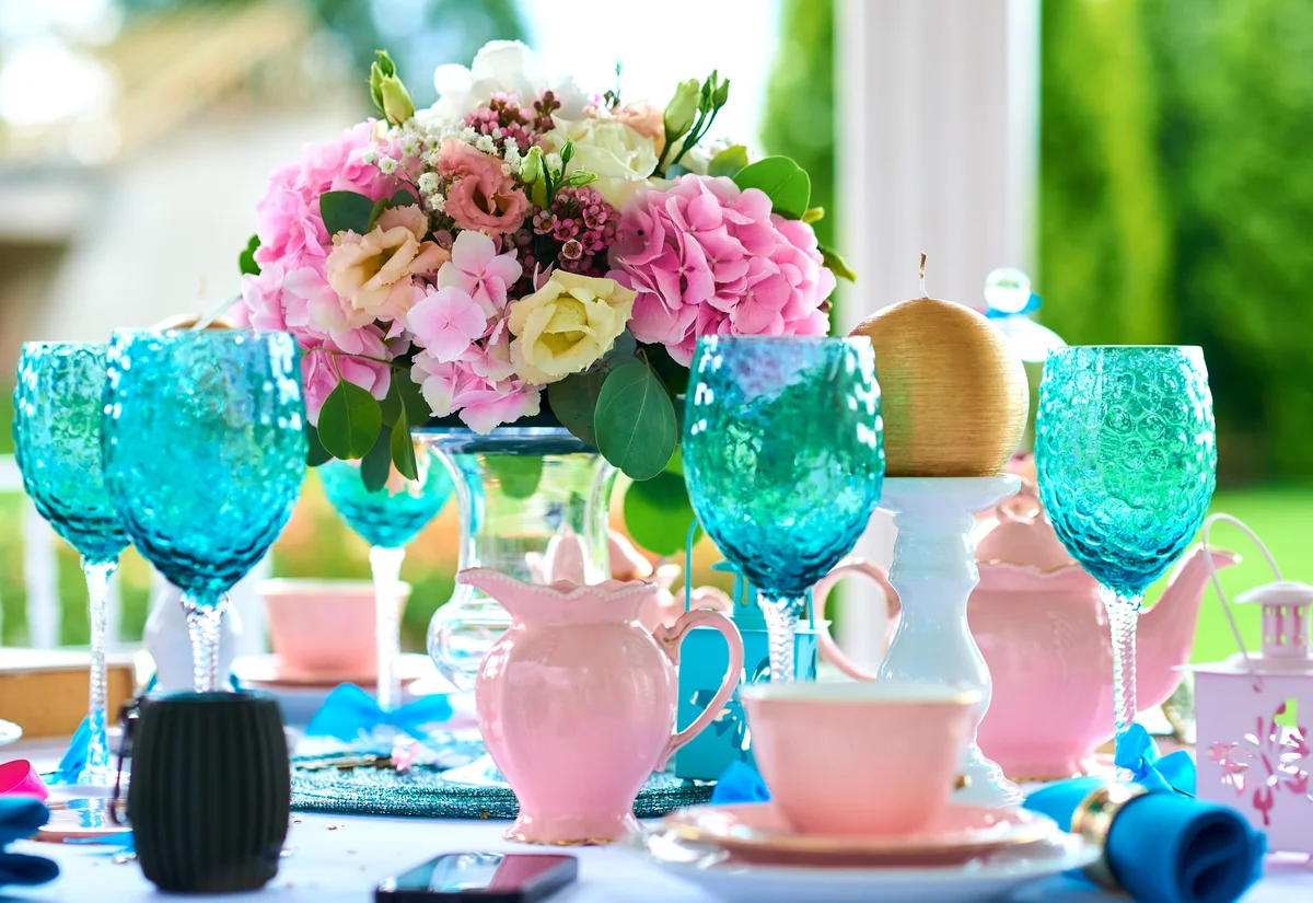 Pink floral arrangement with blue glassware