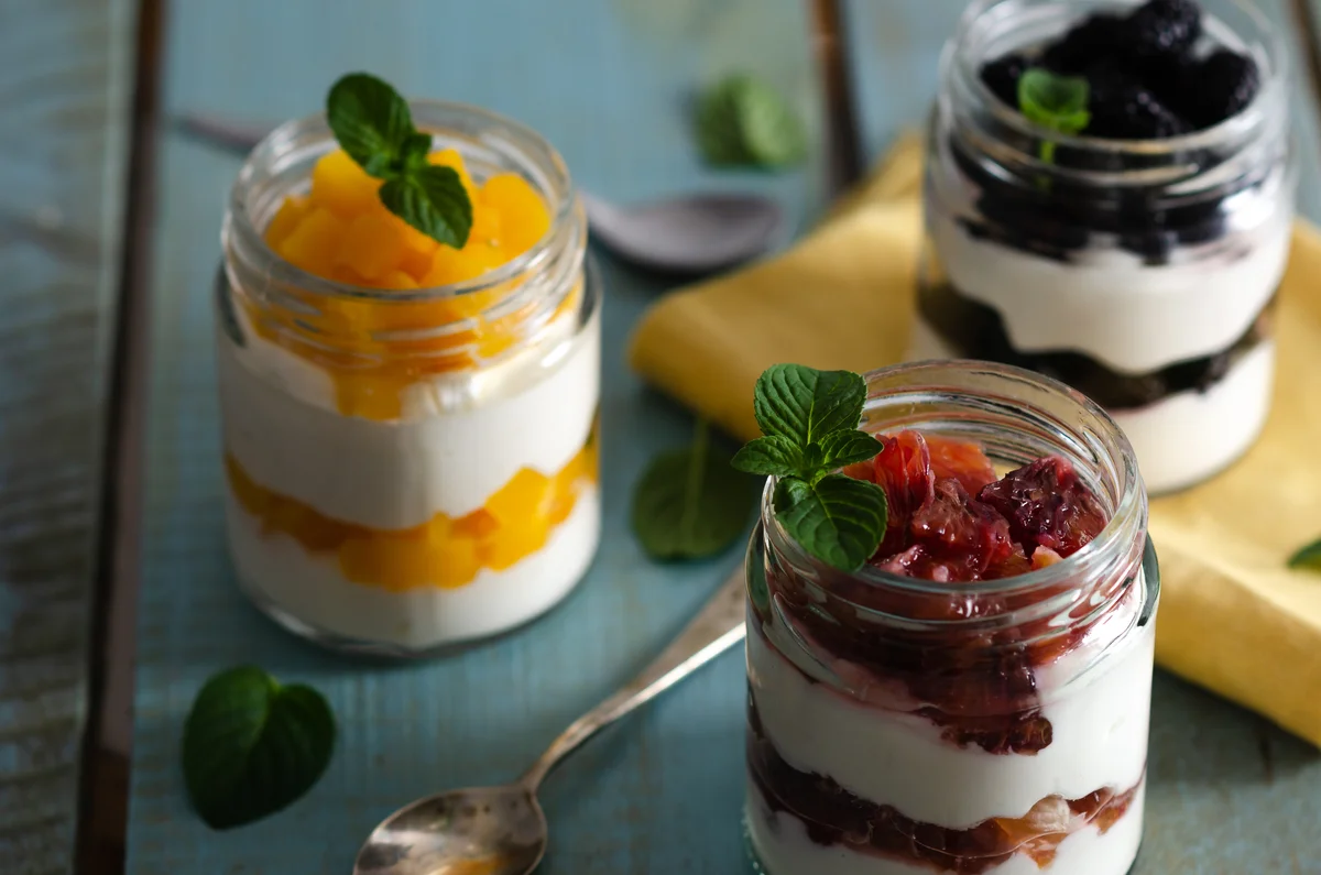 variety of fruit parfaits in mason jars