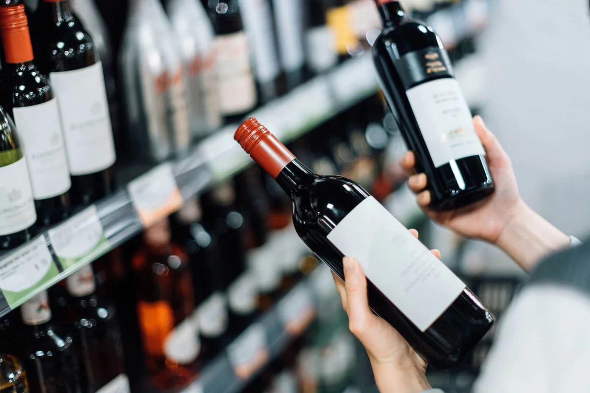 woman choosing bottles of red wine