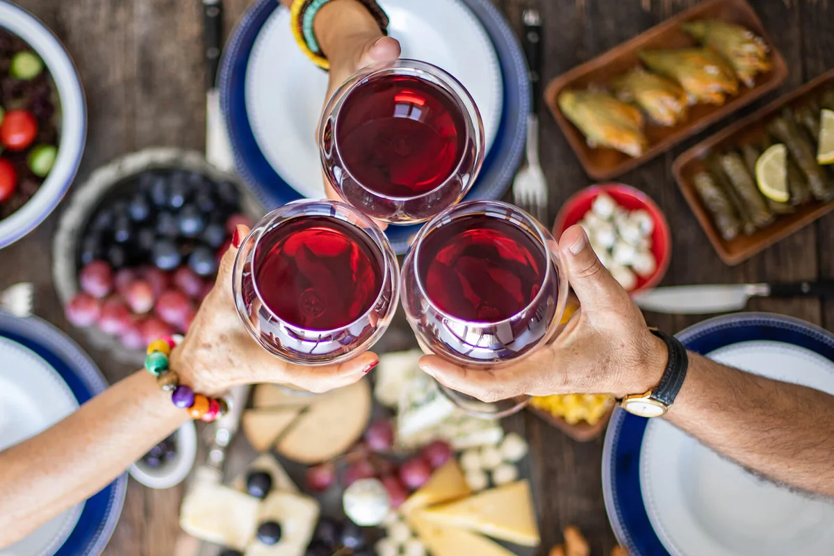 Family dinner for a celebration with red wine and cheers