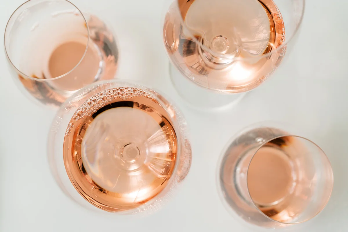 Glasses of rose wine on white background