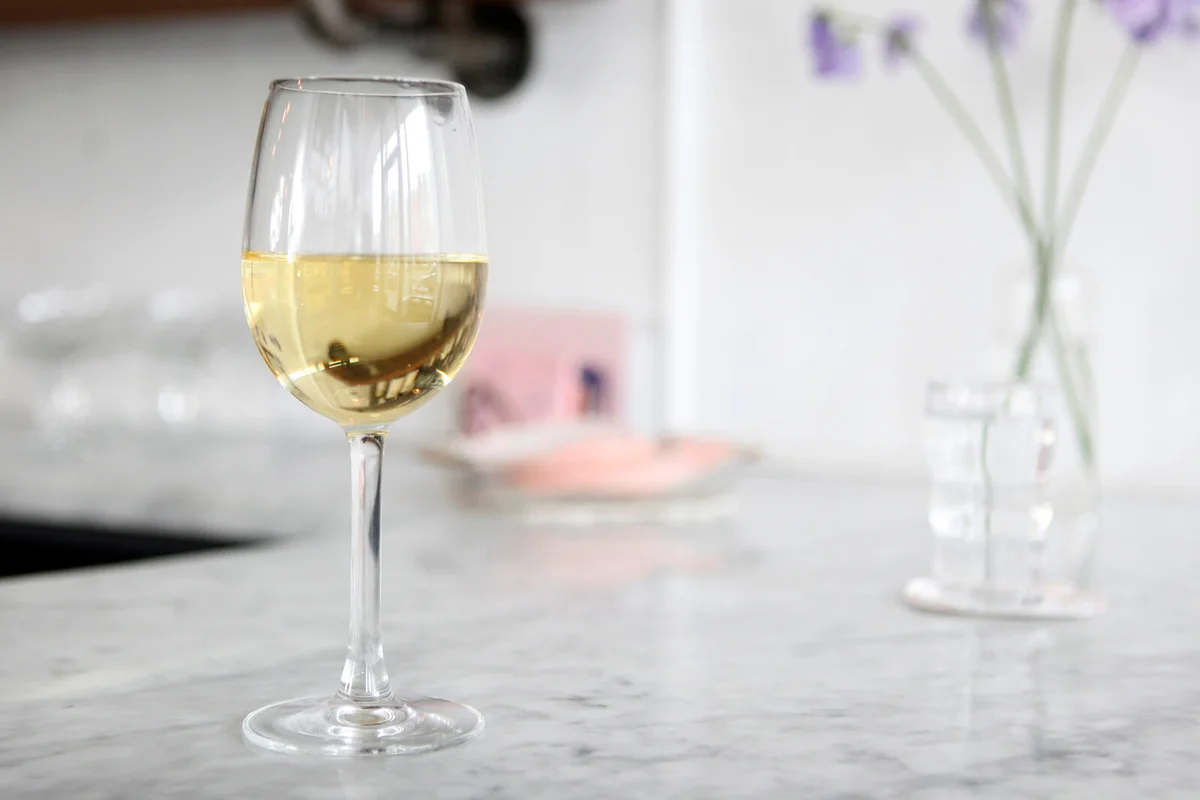 Glass of white wine on marble bar counter in wine bar