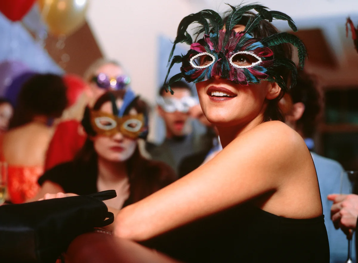girl at party wearing feathered mask