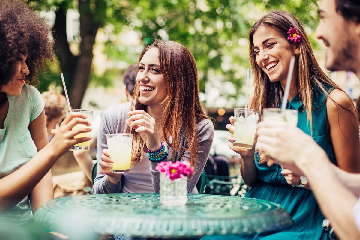 women sitting outside and drinking iced drinks