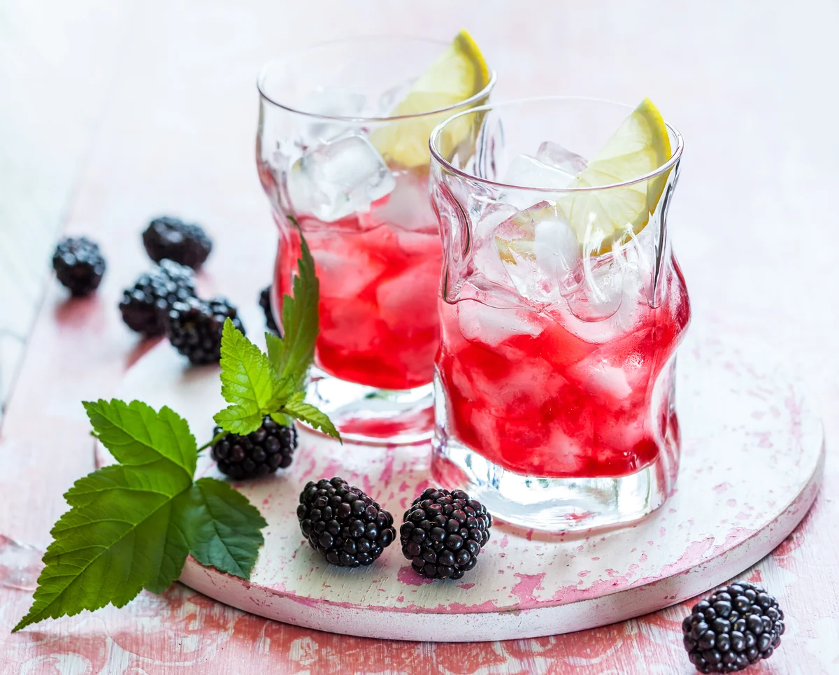 Blackberry lemonade beverage on a vintage wooden board