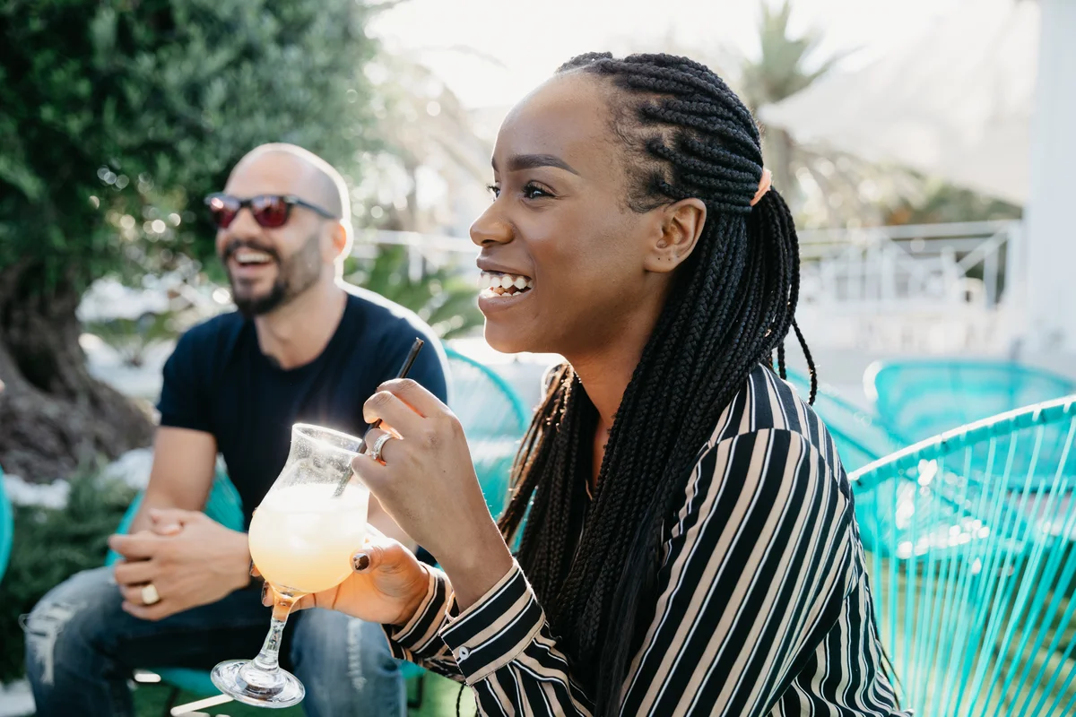 Woman enjoying refreshing drink outside with friends