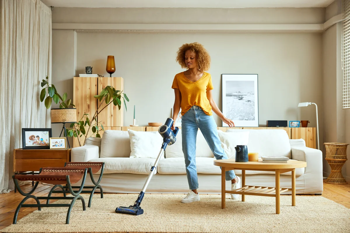 woman vaccuming living room