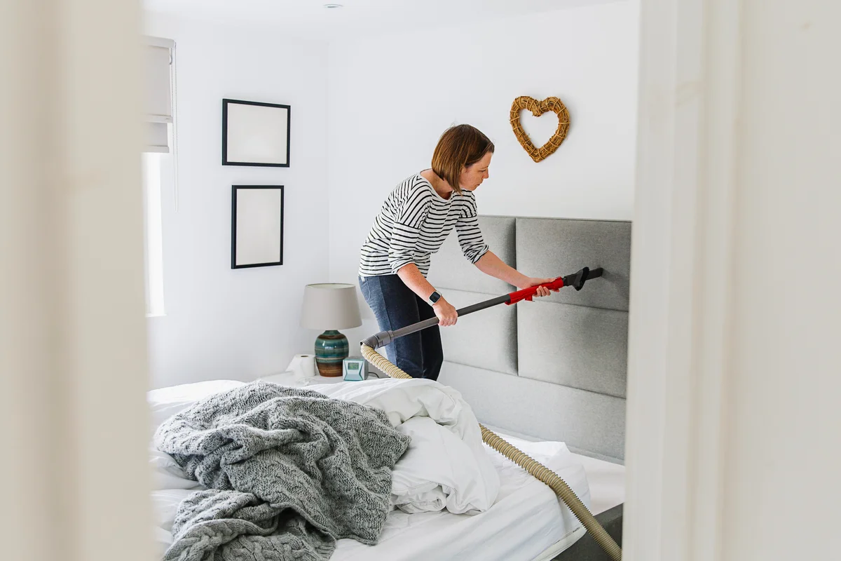 woman deep cleaning her bedroom