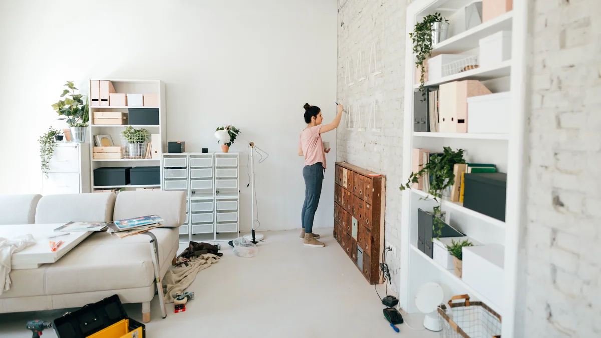 woman touching up walls with paint