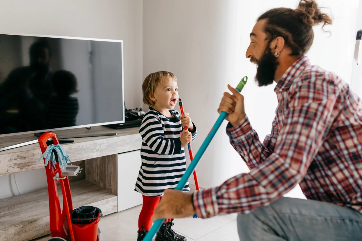 father and son having fun while cleaning