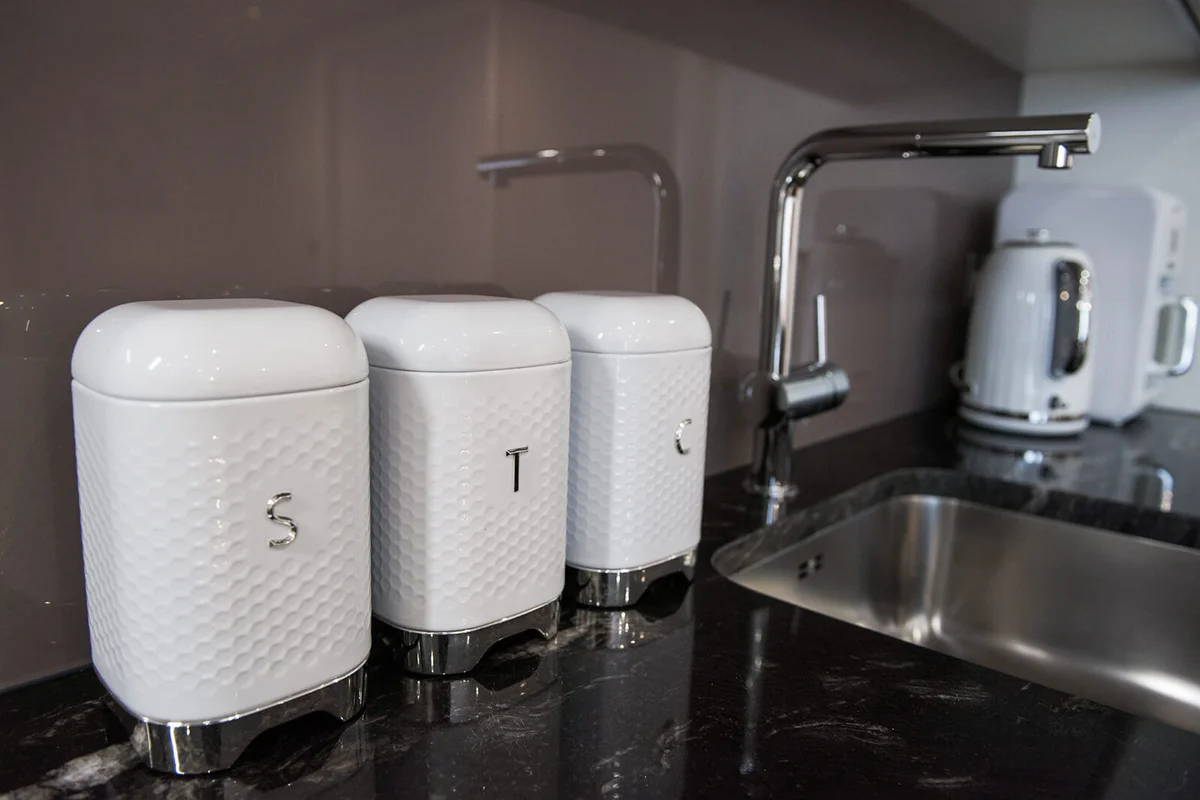 White square Tea, sugar and coffee canisters on a kitchen worktop
