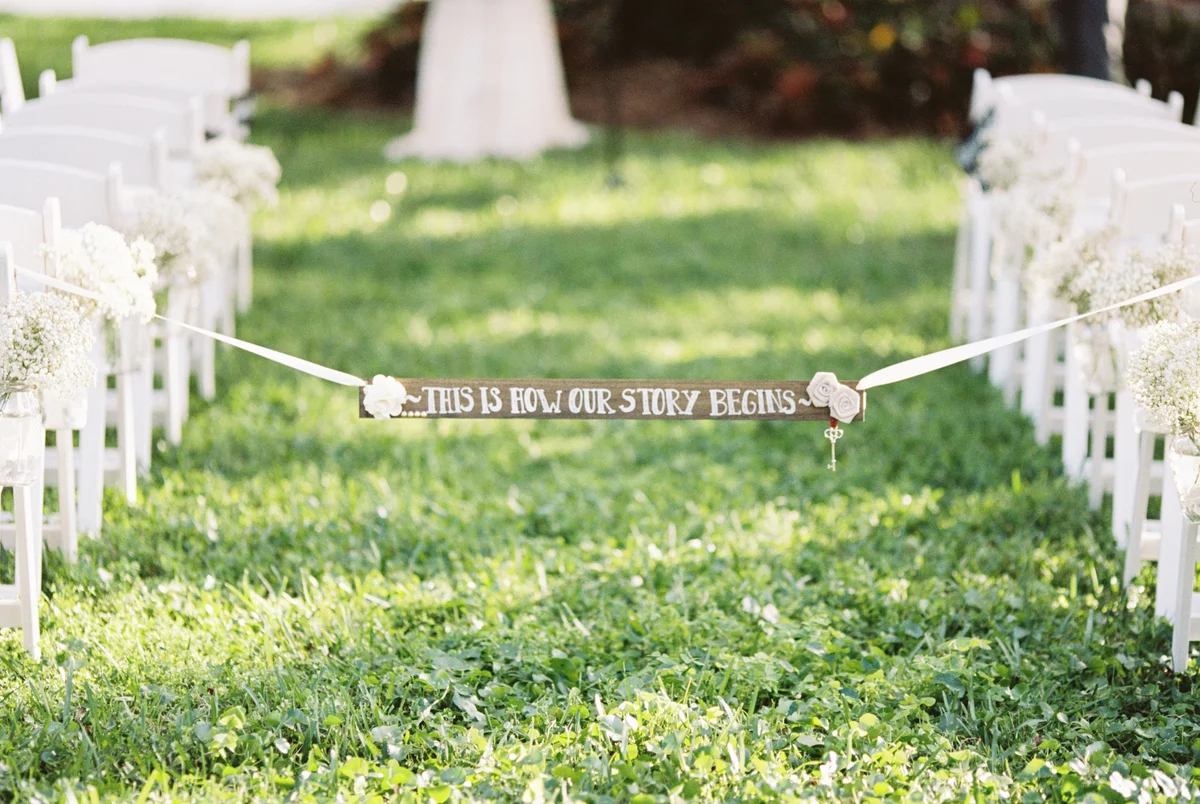 rustic sign across wedding aisle