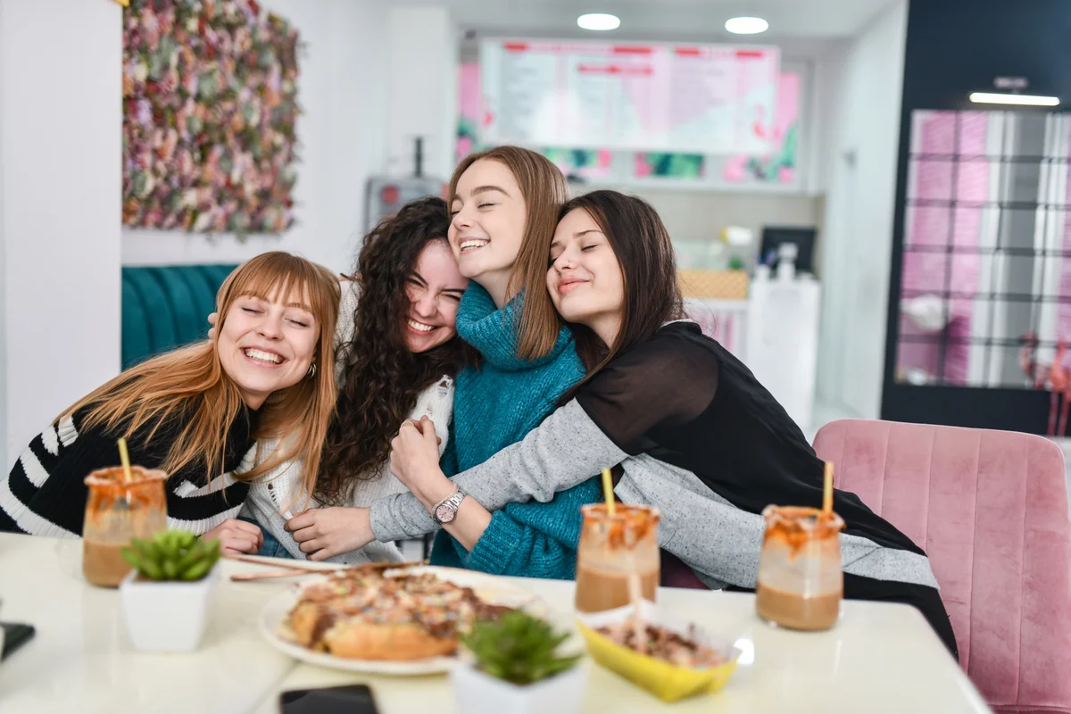 4 girls hugging while they're having brunch