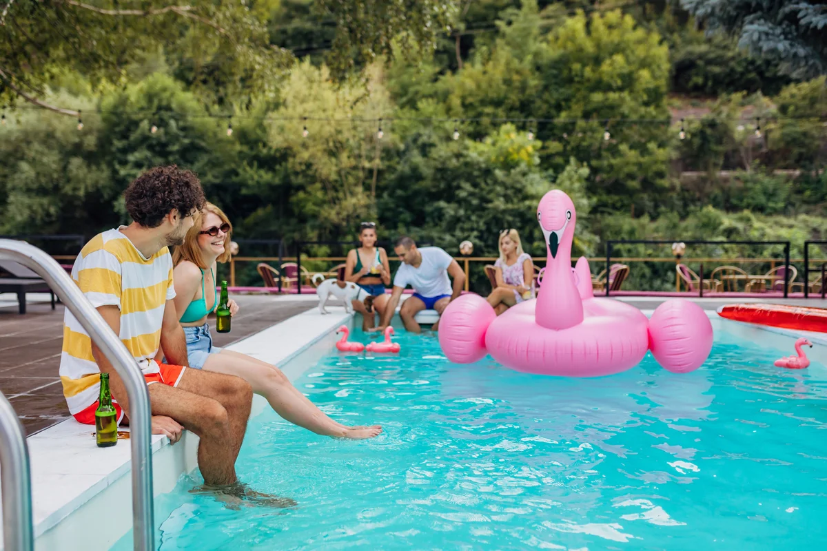 People enjoying tiki party by a pool