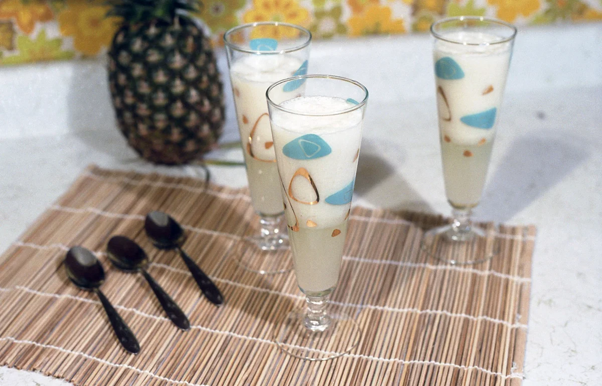drinks on a bamboo placemat next to a pineapple