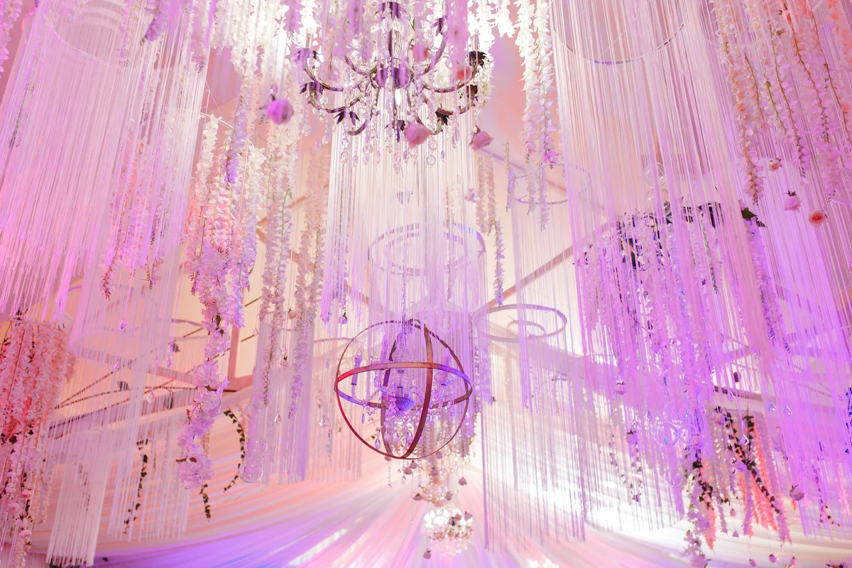 Magnificent chandeliers hang from the white ceiling pink colors